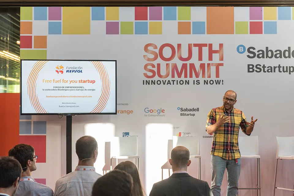 Diego Serrano gesticulando mientras trabaja con un participante en South Summit